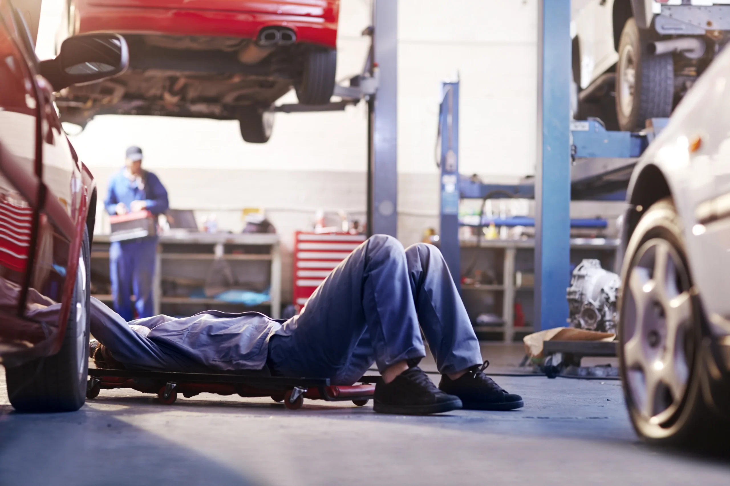 Mechanic working under a vehicle in a repair shop